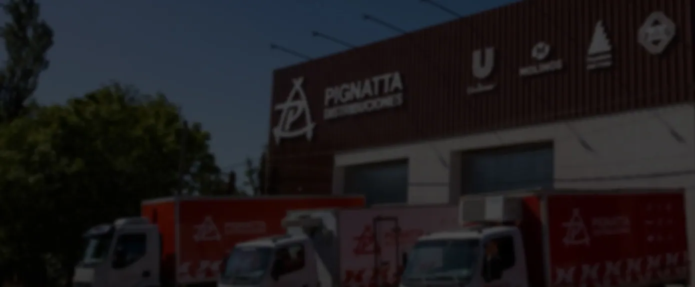 Fachada del depósito de Pignatta Distribuciones de noche, con la flota estacionada